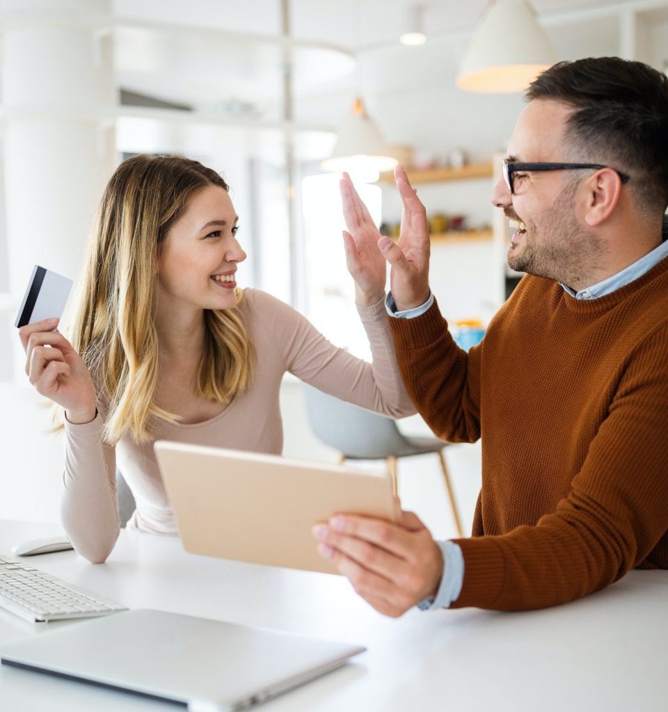 Cheerful young couple doing online shopping with tablet
